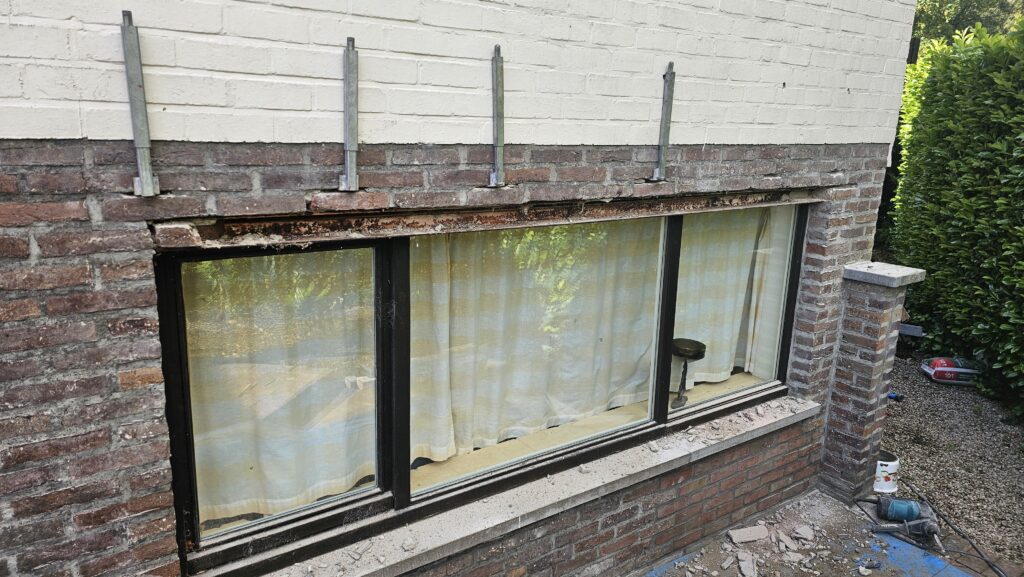 Beschadigde latei boven raam met losgekomen metselwerk in Brugge